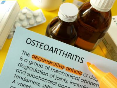 Highlighted text on osteoarthritis document with medicine bottles, yellow highlighter; photo.