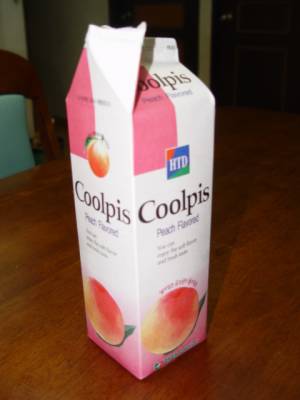Peach-flavored Coolpis carton on table, pink and white, with HTD logo.