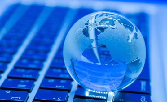 Glass globe resting on blue keyboard, close-up photo, no visible text.