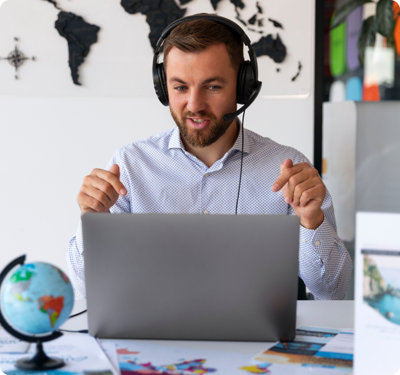 Man with headset video conferencing on laptop, colorful maps, world map background.