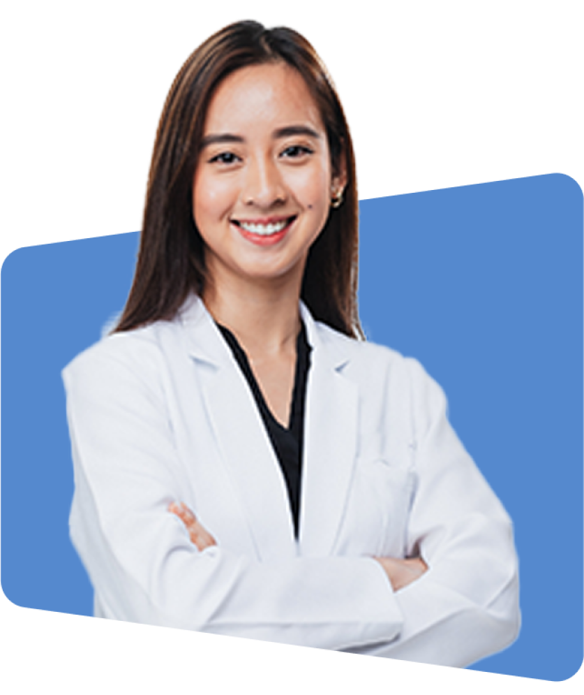 Smiling woman in white coat, arms crossed, against blue background, photo.