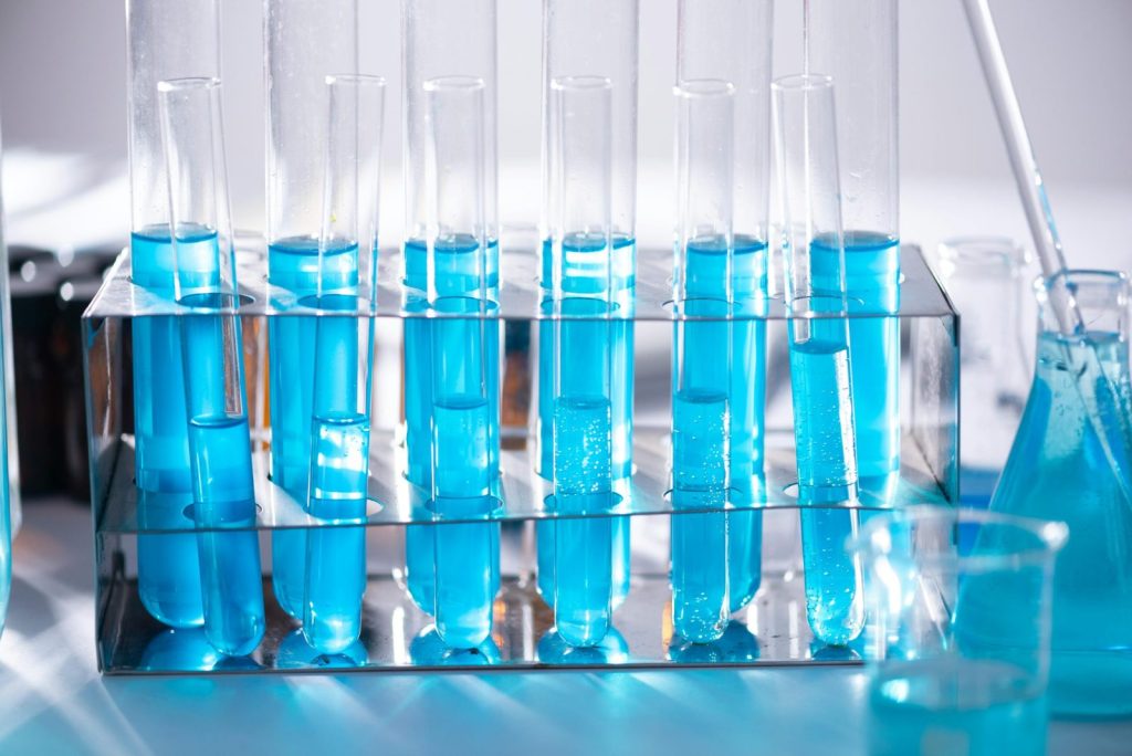 Test tubes filled with blue liquid in a laboratory setting, photo.