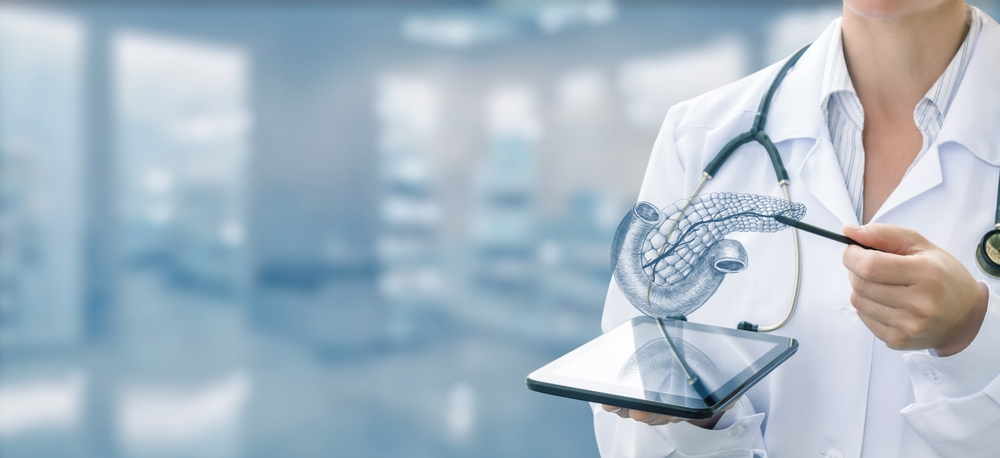 Doctor holding tablet with digital pancreas illustration, in a clinical setting.